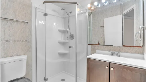 a bathroom with a shower sink vanity and mirror