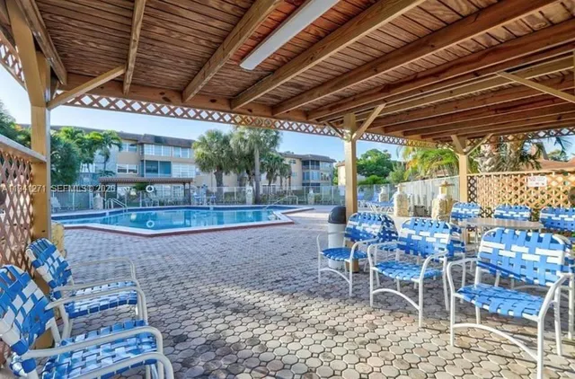 a view of a chairs and table in patio with a wooden fence