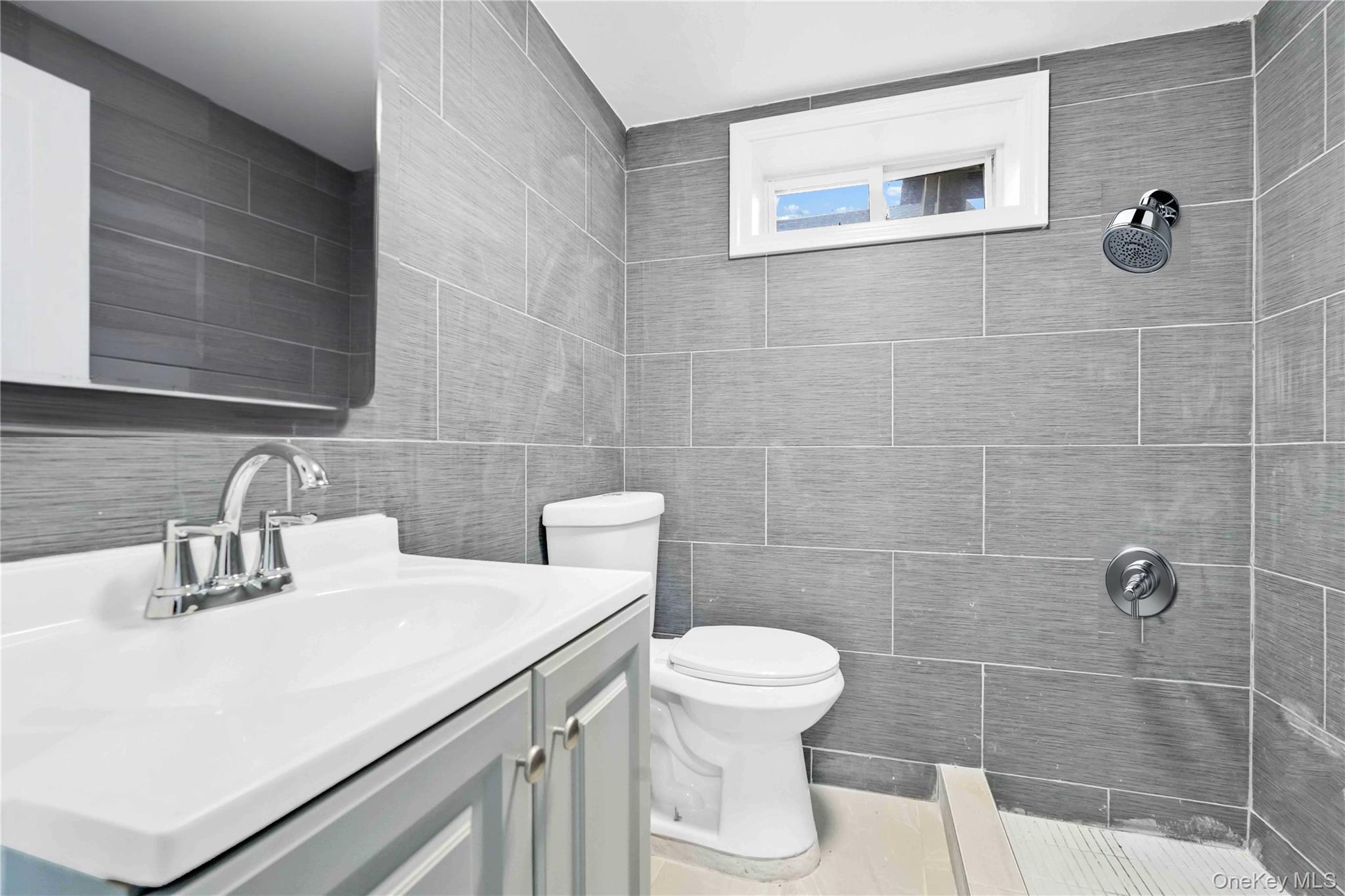 21432 112th Road Queens, NY 11429 - Photo 15 of 18 Bathroom with vanity, a tile shower, and tile walls