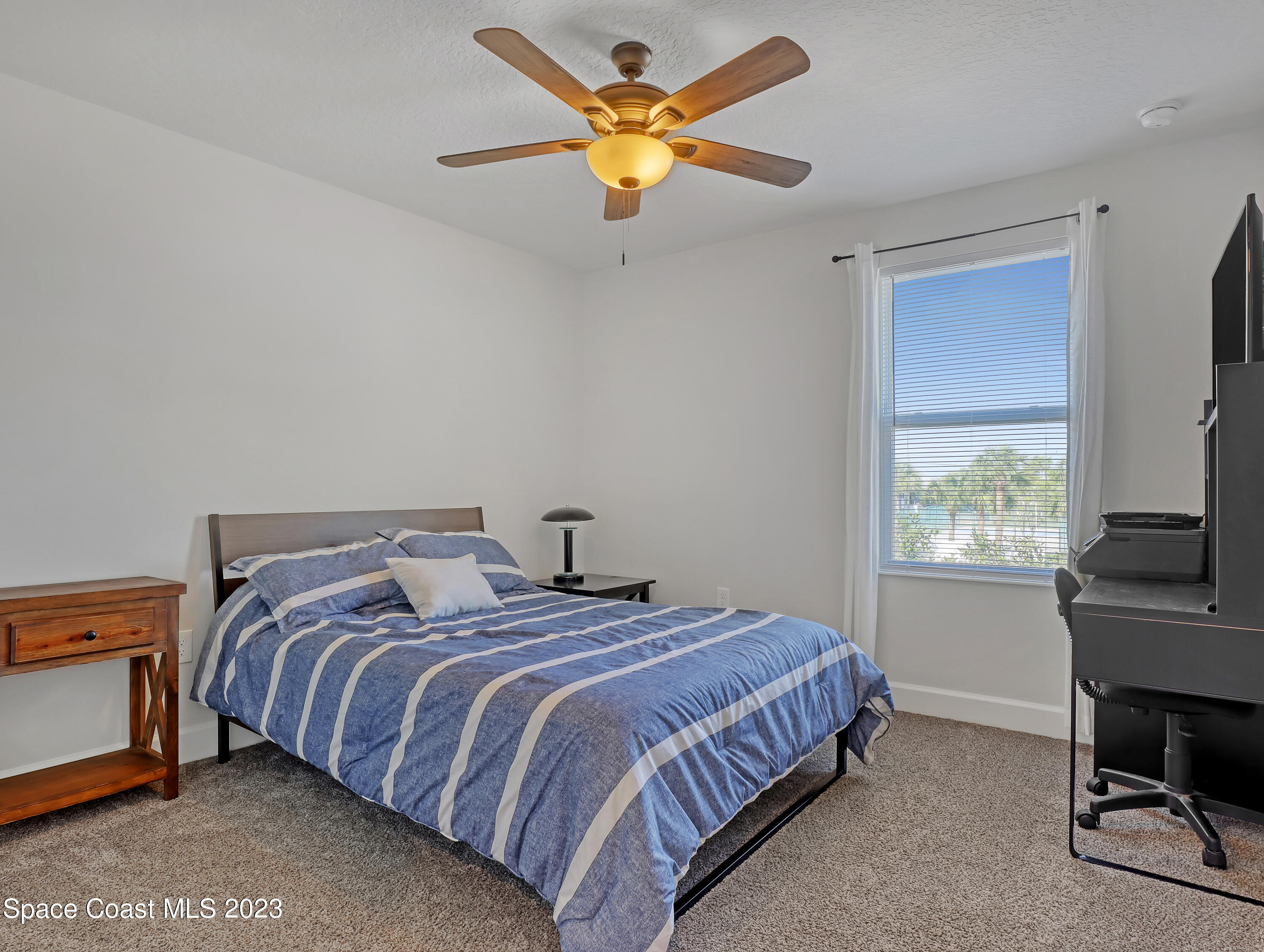 1807 Elkins Point Melbourne, FL 32935 - Photo 36 of 52 a bedroom with a bed a window and a flat screen tv