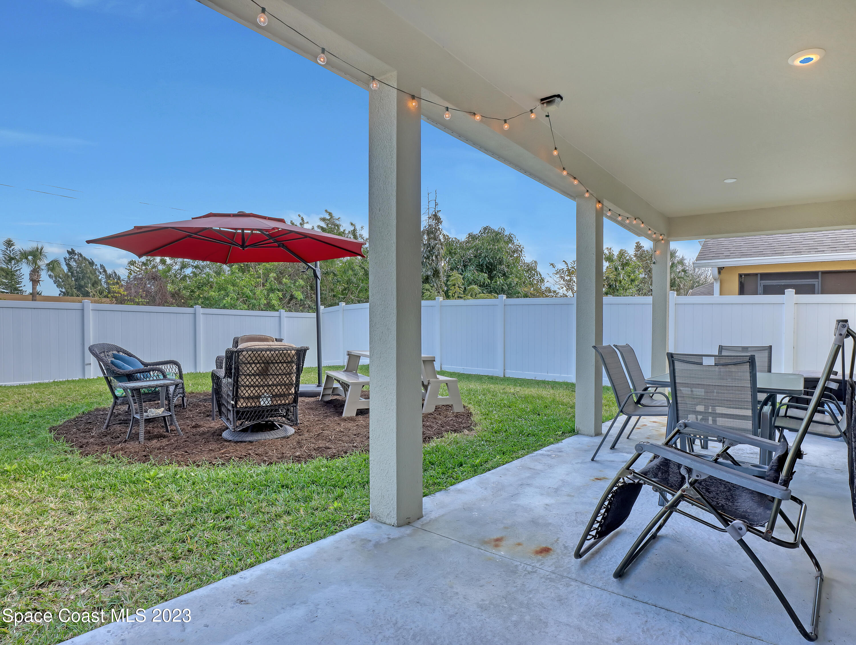 1807 Elkins Point Melbourne, FL 32935 - Photo 41 of 52 a view of a patio with table and chairs under an umbrella with a barbeque