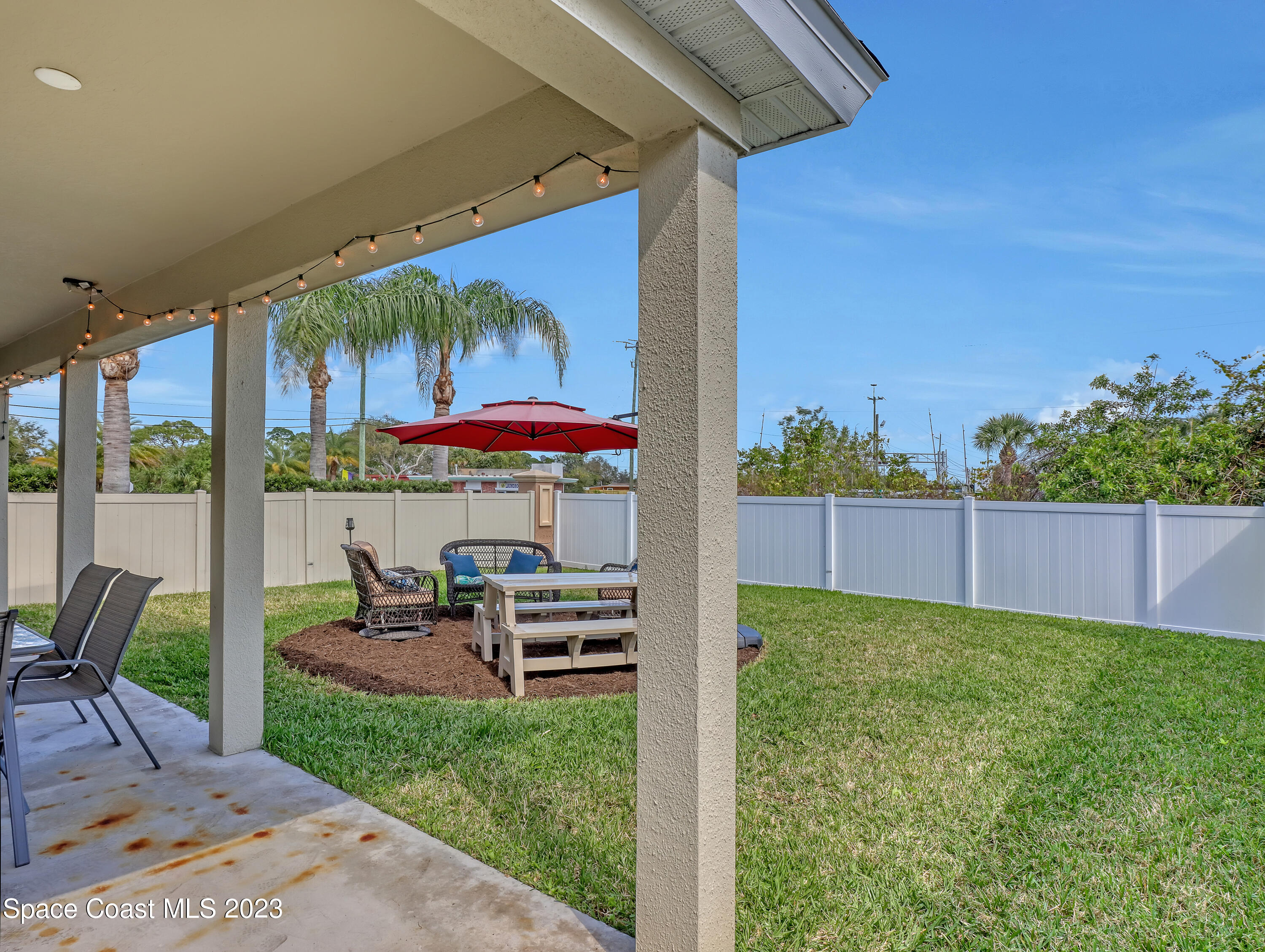 1807 Elkins Point Melbourne, FL 32935 - Photo 43 of 52 a view of a chairs and table in patio with a yard