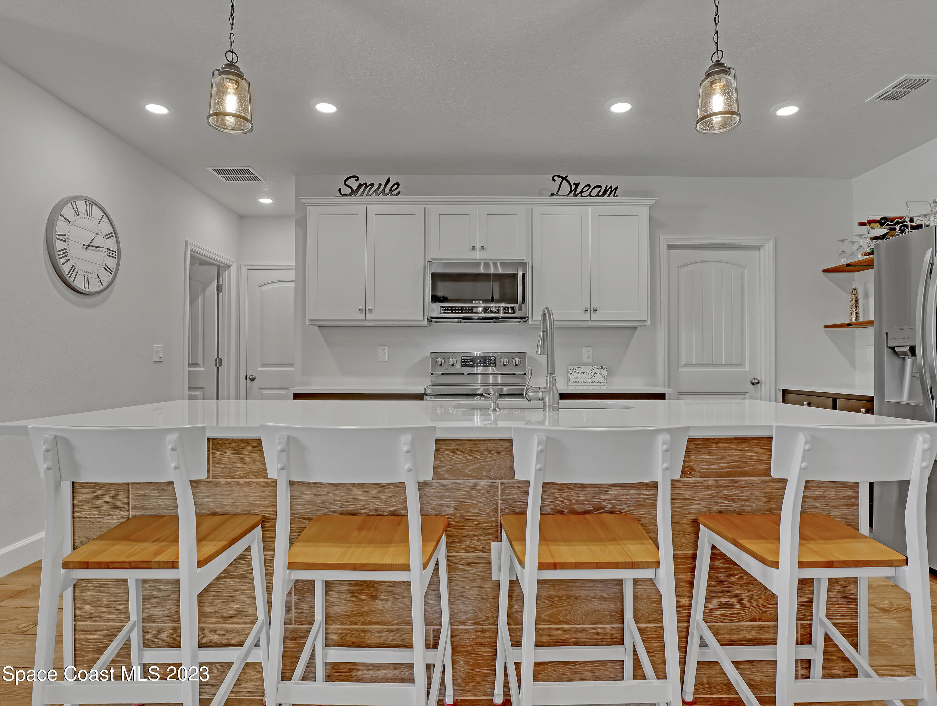 1807 Elkins Point Melbourne, FL 32935 - Photo 10 of 52 a kitchen with a dining table chairs cabinets and stainless steel appliances
