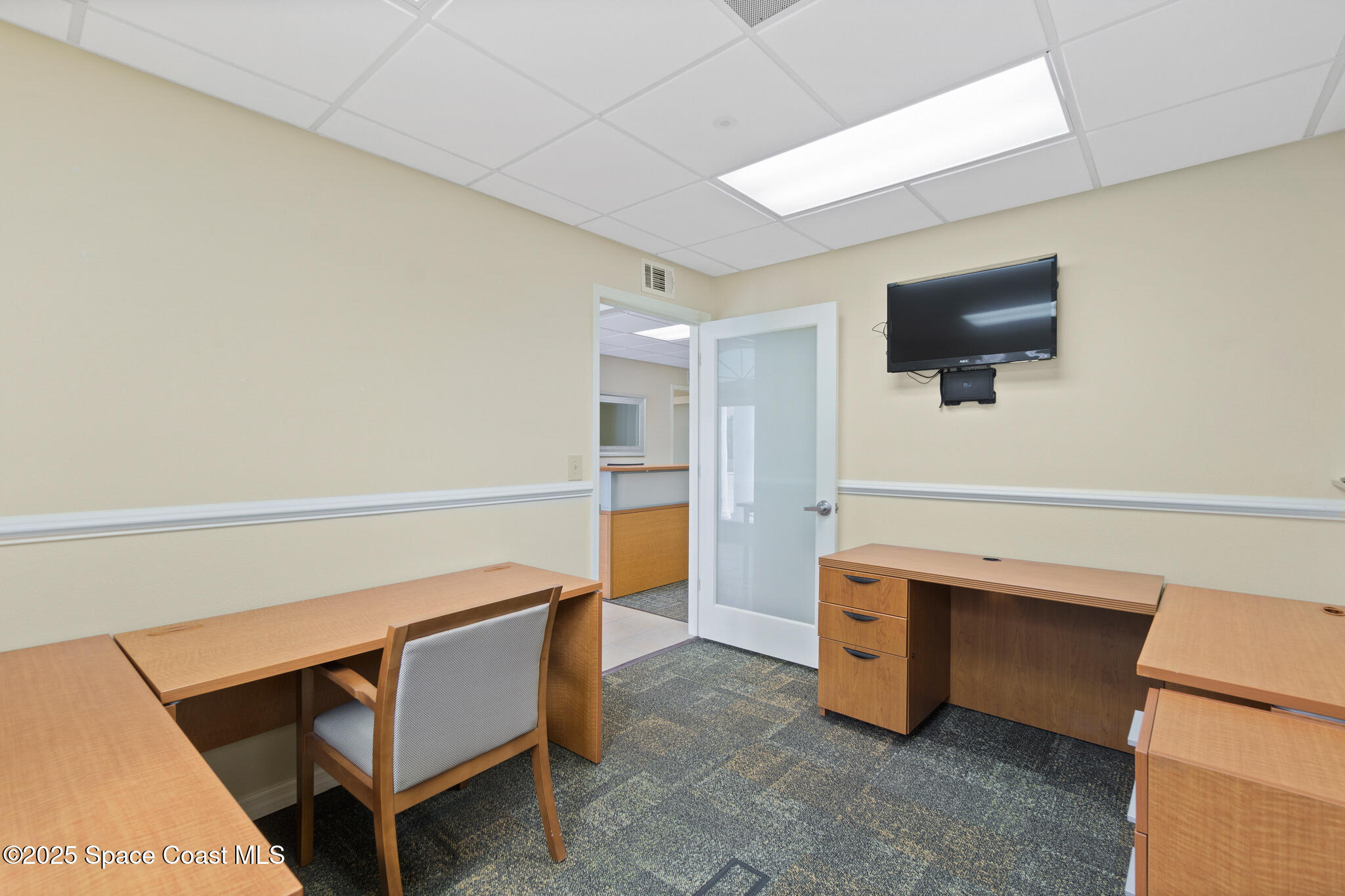38 Suntree Place, Unit 2 Melbourne, FL 32940 - Photo 43 of 52 a living room with a desk and a flat screen tv