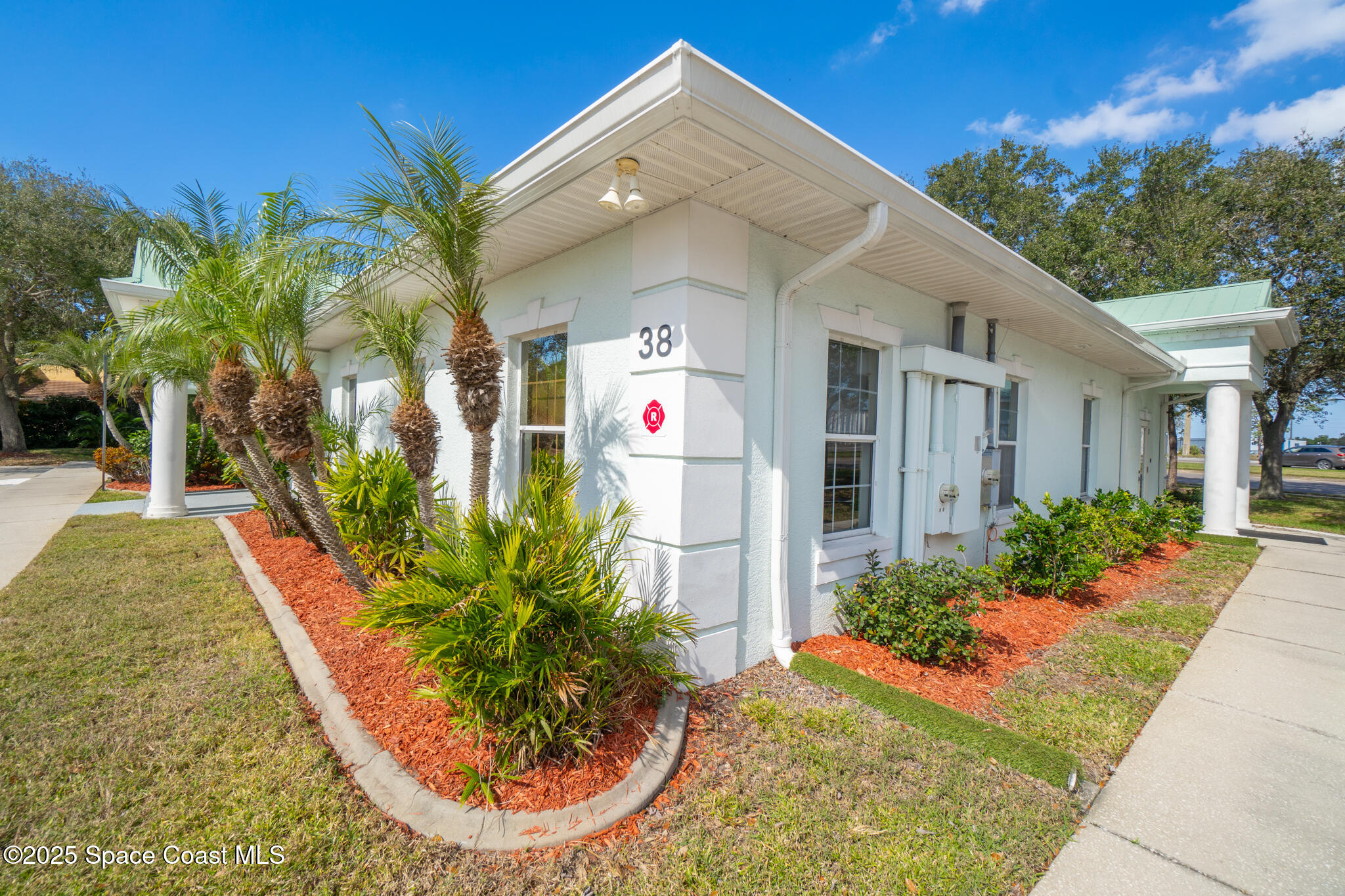 38 Suntree Place, Unit 2 Melbourne, FL 32940 - Photo 8 of 52 a view of a white house with a yard potted plants and floor to ceiling window