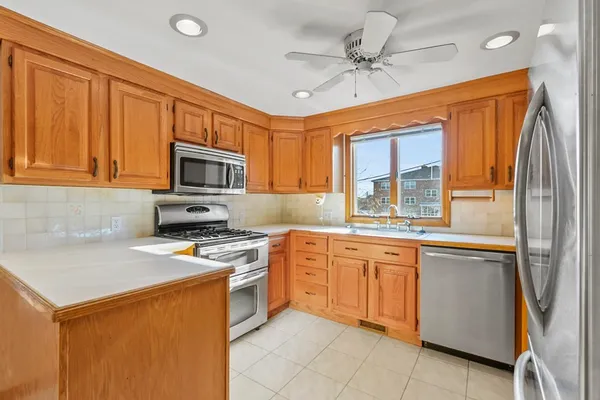 a kitchen with stainless steel appliances granite countertop a stove refrigerator sink and microwave