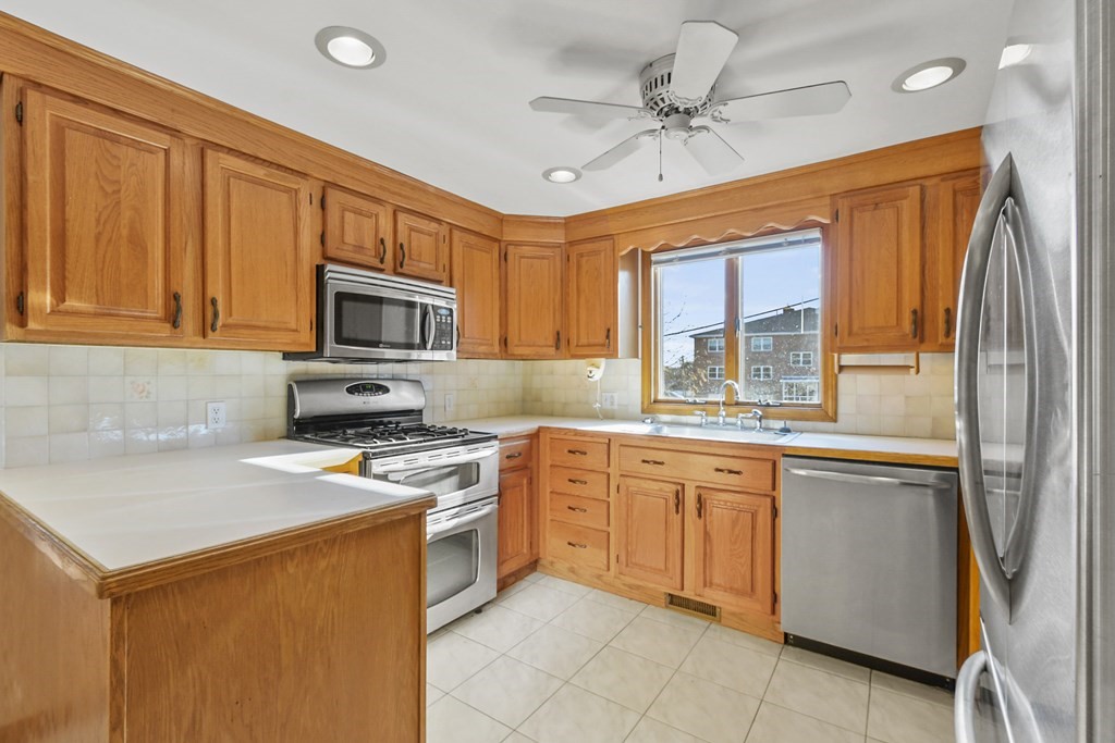 72 Cambridge Road, Unit 2 Woburn, MA 01801 - Photo 14 of 30 a kitchen with stainless steel appliances granite countertop a stove refrigerator sink and microwave