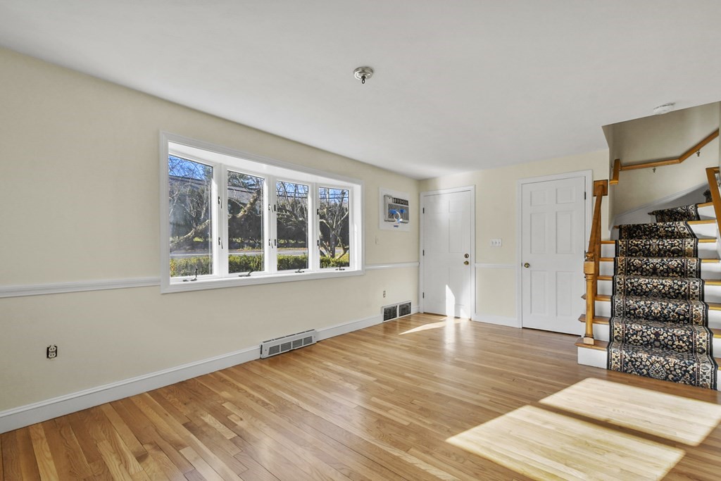 72 Cambridge Road, Unit 2 Woburn, MA 01801 - Photo 17 of 30 a view of an empty room with wooden floor and windows