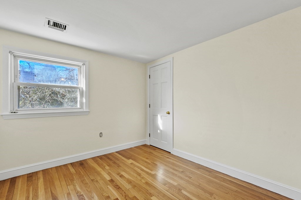 72 Cambridge Road, Unit 2 Woburn, MA 01801 - Photo 18 of 30 a view of an empty room with wooden floor and a window