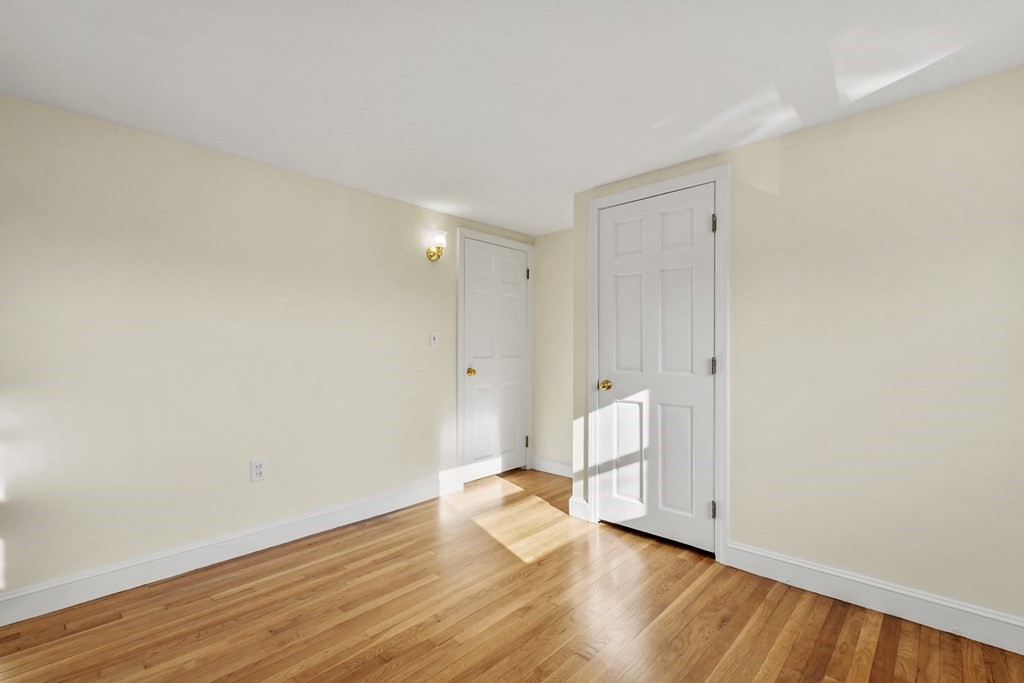 72 Cambridge Road, Unit 2 Woburn, MA 01801 - Photo 22 of 30 a view of an empty room with wooden floor and a window