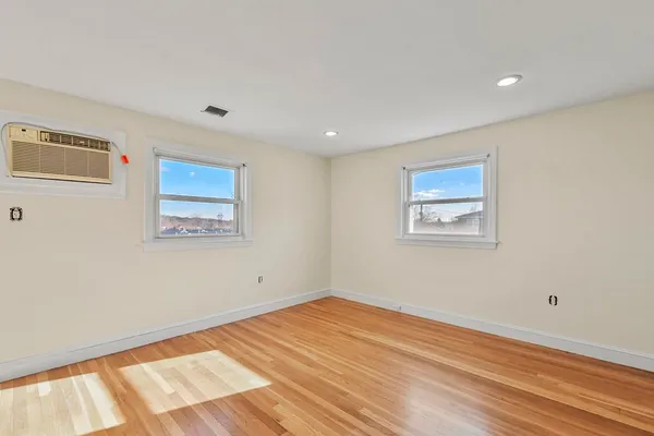 a view of empty room with wooden floor