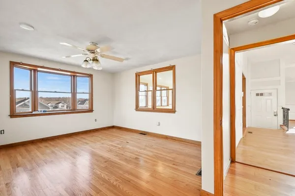 a view of an empty room with a window and wooden floor