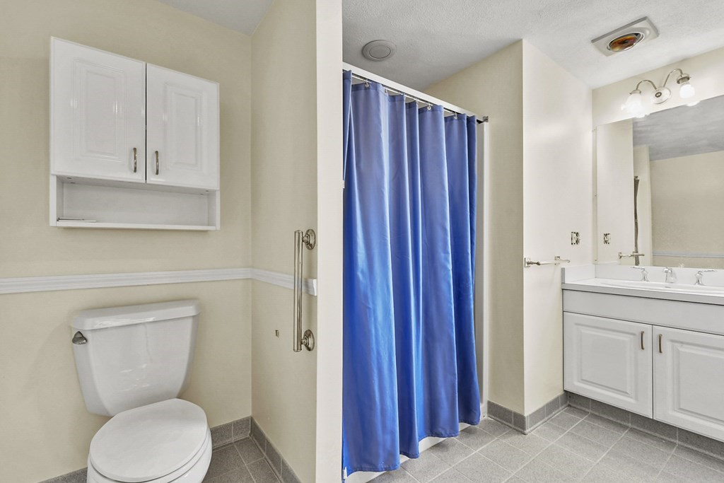 72 Cambridge Road, Unit 2 Woburn, MA 01801 - Photo 7 of 30 a bathroom with a toilet a sink and mirror