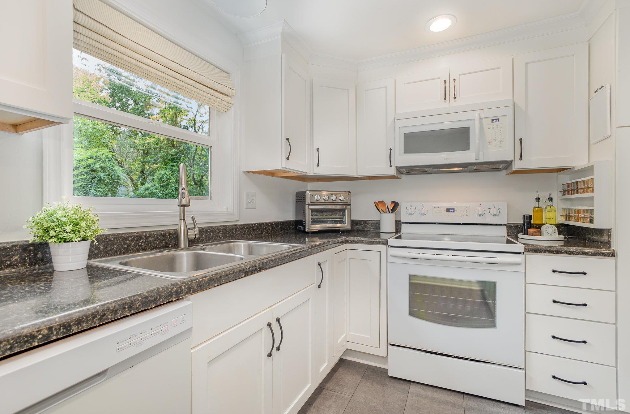 710 Tyler Road Raleigh, NC 27604 - Photo 11 of 27 a kitchen with granite countertop white cabinets and white stainless steel appliances