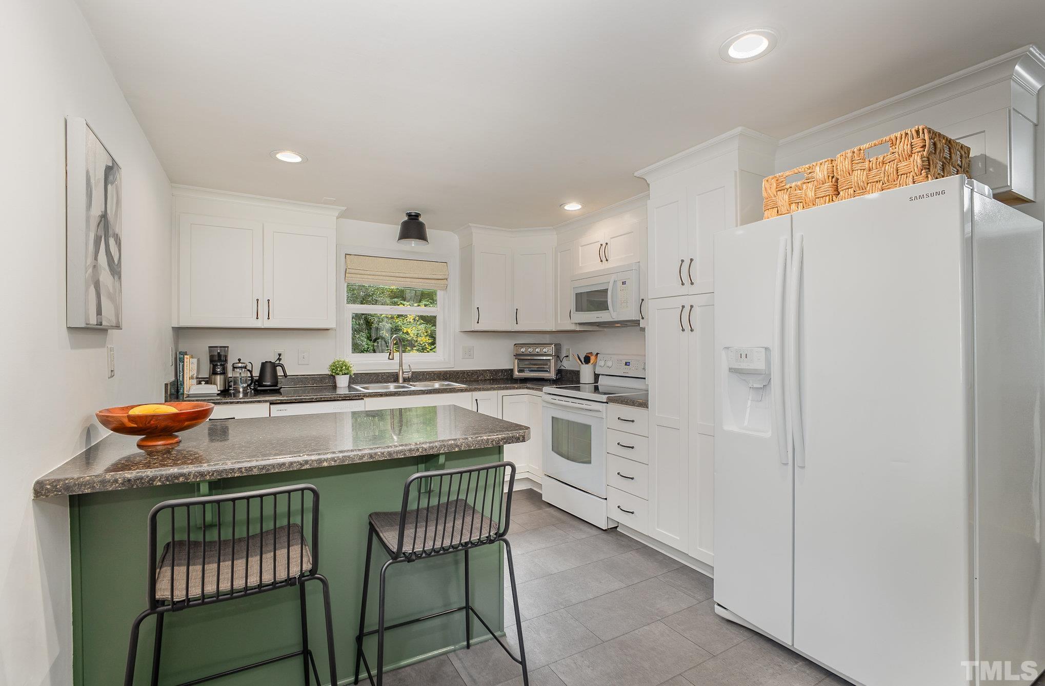 710 Tyler Road Raleigh, NC 27604 - Photo 10 of 27 a kitchen with stainless steel appliances granite countertop a refrigerator and a stove top oven