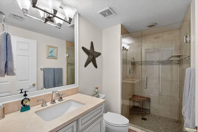 a front view of a multi story residential apartment building with yard and green space