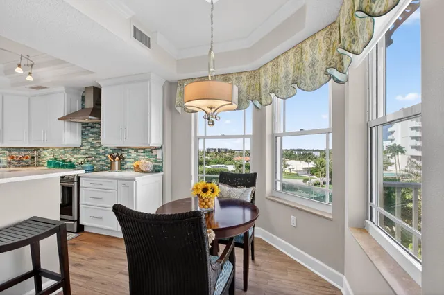 a kitchen with refrigerator a stove and wooden floor