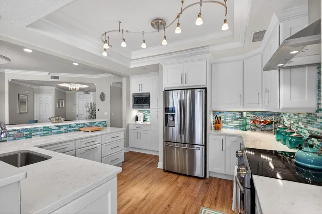 a kitchen with granite countertop white cabinets and stainless steel appliances