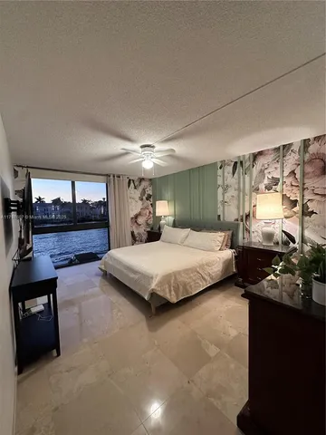 a bedroom with a large bed and a large window