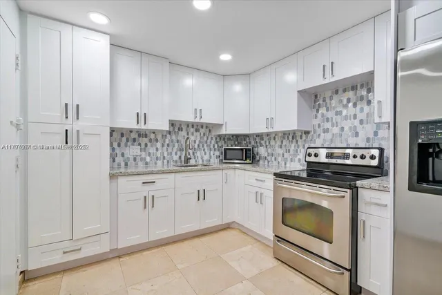 a kitchen with stainless steel appliances granite countertop a stove a sink and a refrigerator
