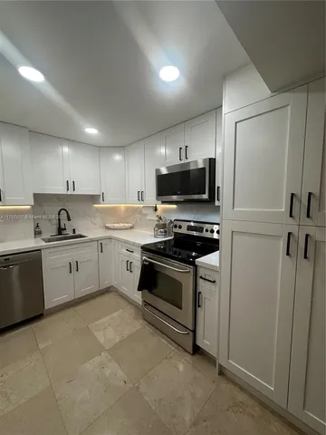 a large kitchen with cabinets and stainless steel appliances