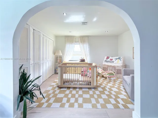 a bedroom with a large bed and a chandelier