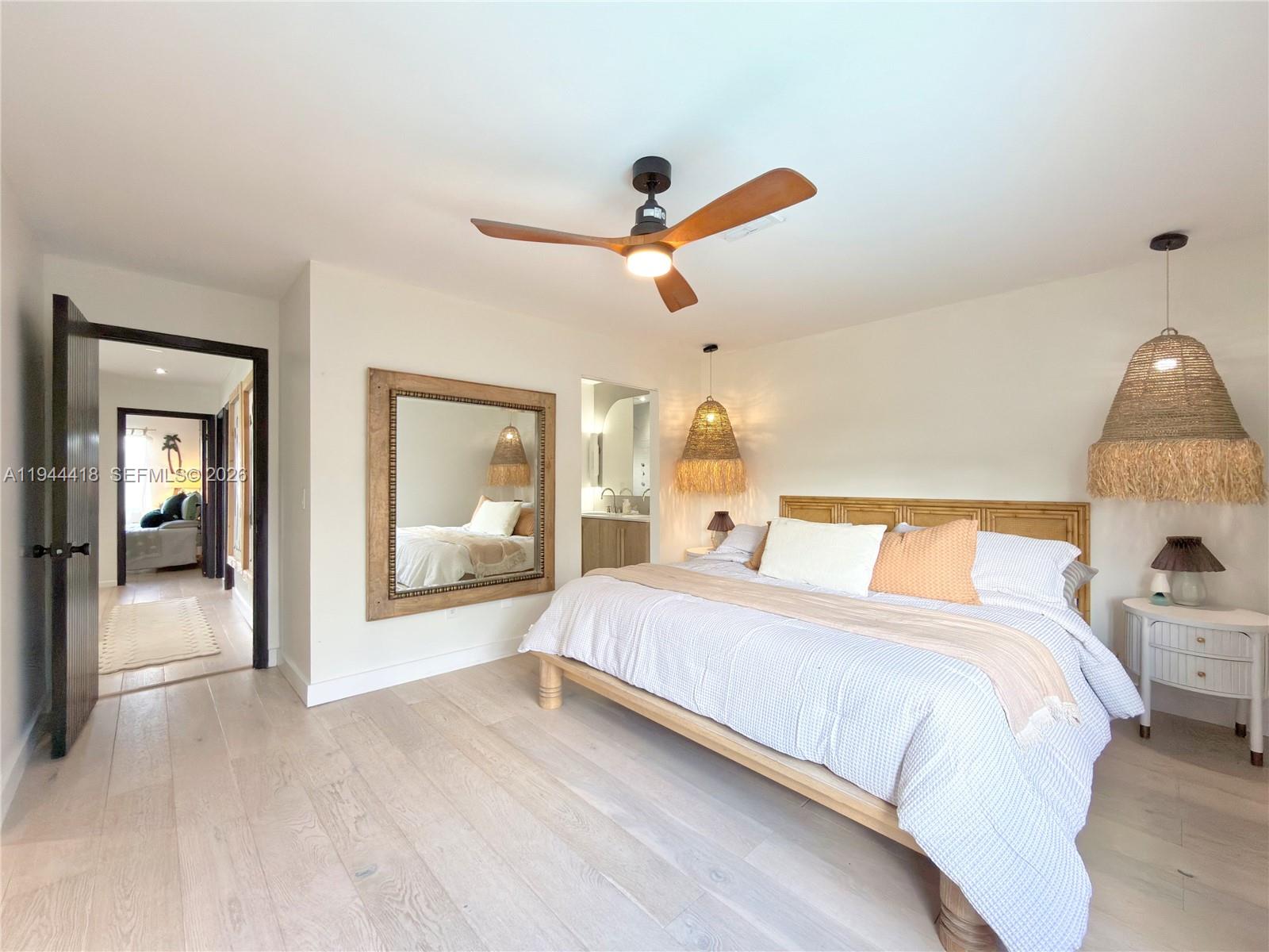 760 Windtree Way Wellington, FL 33414 - Photo 33 of 45 a bedroom with a large bed and a chandelier