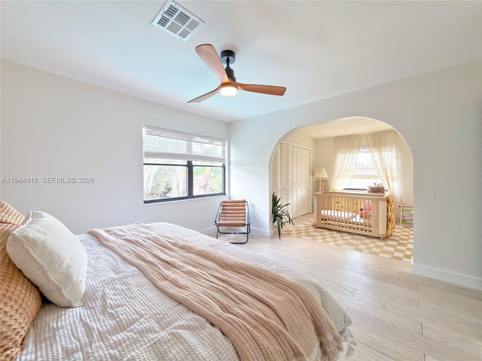 760 Windtree Way Wellington, FL 33414 - Photo 35 of 45 a bedroom with a bed a large mirror and a large window