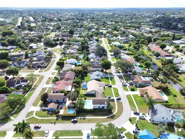 an aerial view of residential houses with outdoor space and parking