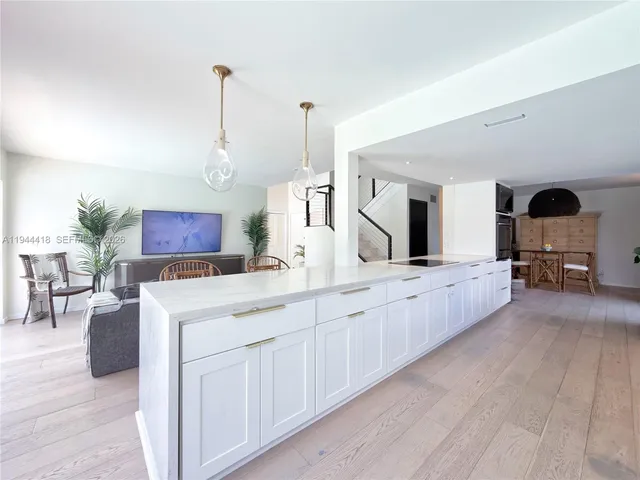 a large white kitchen with cabinets
