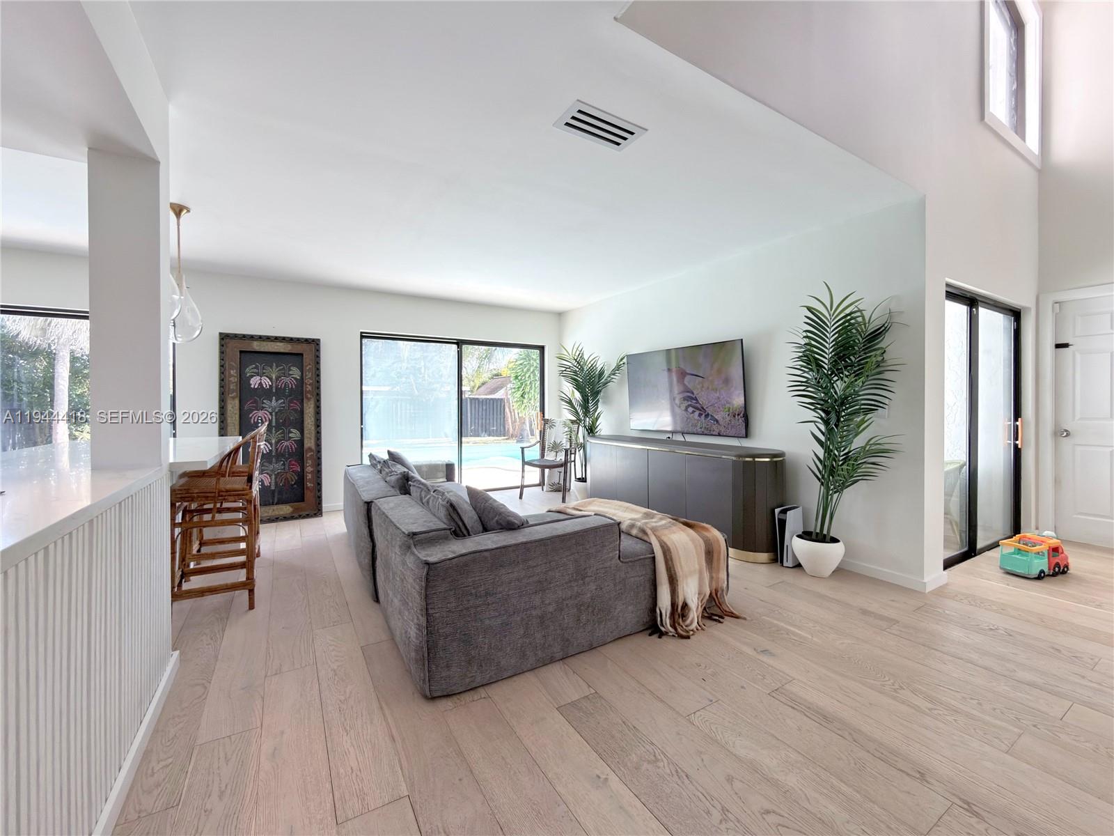 760 Windtree Way Wellington, FL 33414 - Photo 7 of 45 a living room with furniture a large window and wooden floor