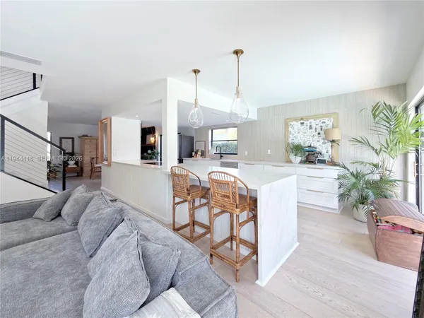 a living room with furniture kitchen view and a chandelier
