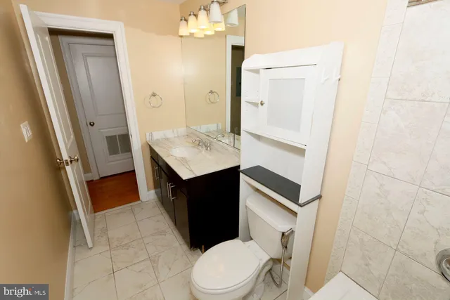 a bathroom with a granite countertop sink toilet and shower