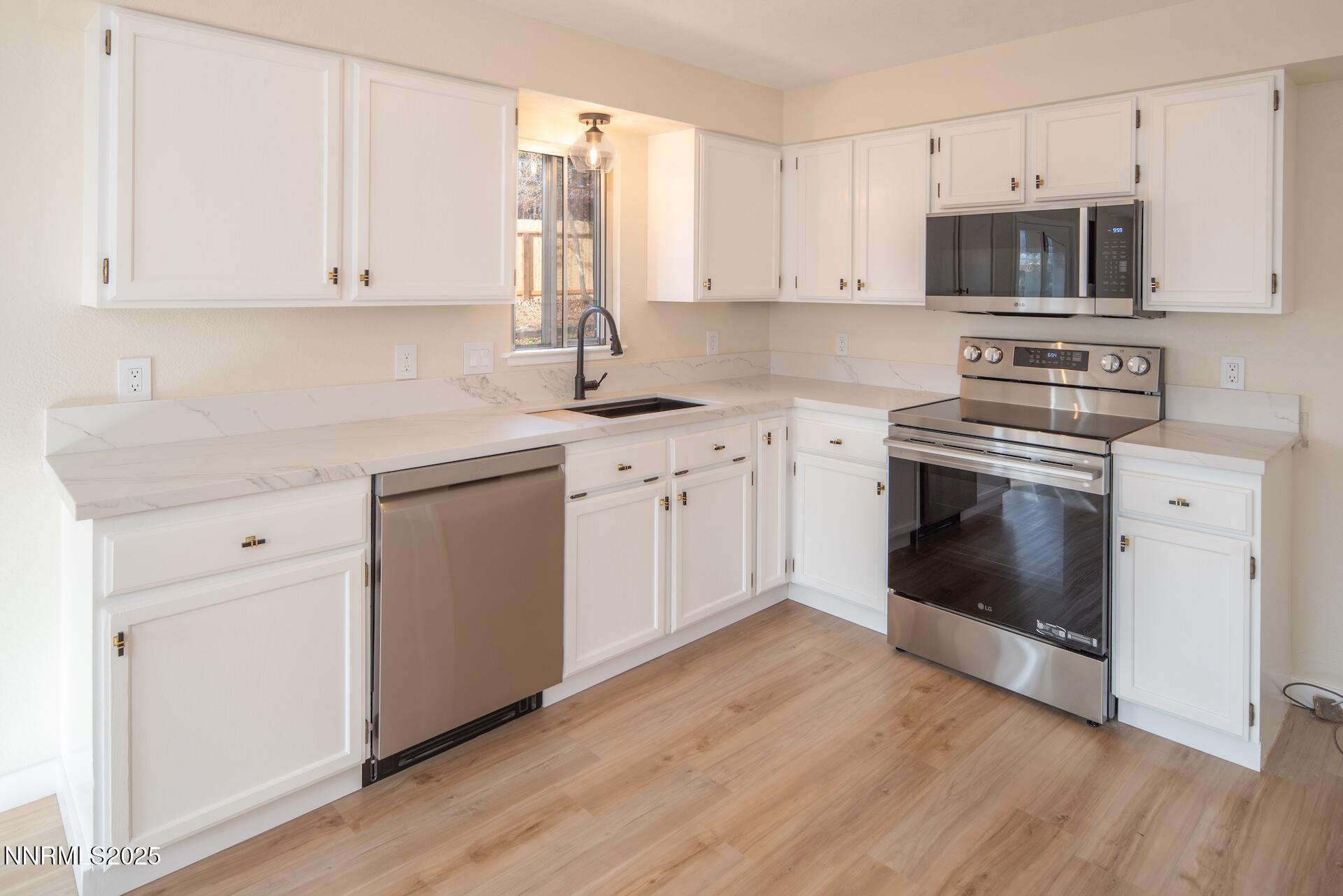 1605 Alamo Street Reno, NV 89503 - Photo 21 of 44 a kitchen with cabinets stainless steel appliances and wooden floor