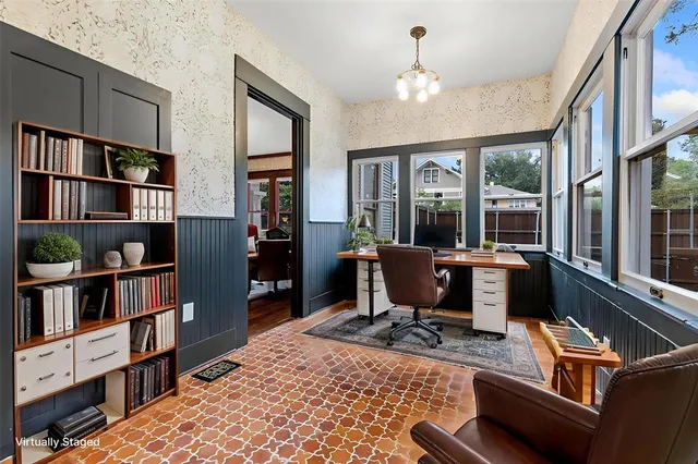 a view of a workspace with furniture and a book shelf