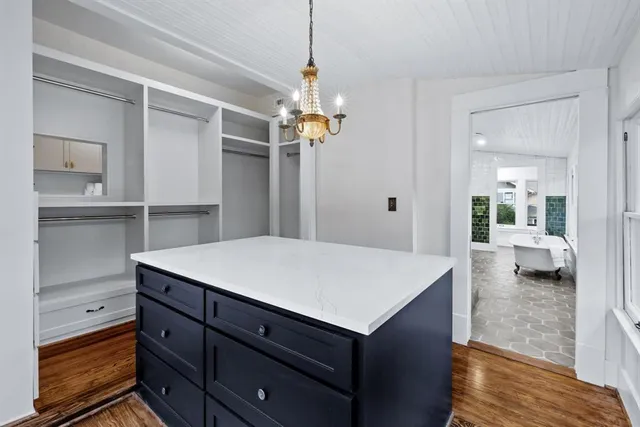 a view of a center kitchen island with cabinets and wooden floor