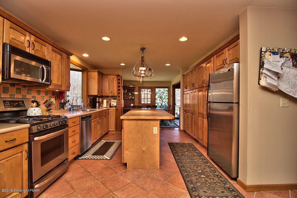 465 Pensyl Creek Road Stroudsburg, PA 18360 - Photo 11 of 80 a kitchen with stainless steel appliances granite countertop a refrigerator a stove and a sink with wooden floor