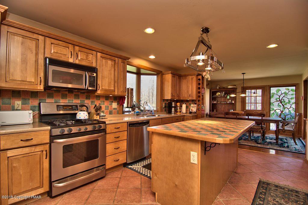 465 Pensyl Creek Road Stroudsburg, PA 18360 - Photo 12 of 80 a kitchen with stainless steel appliances granite countertop a stove top oven a sink dishwasher and white cabinets with wooden floor