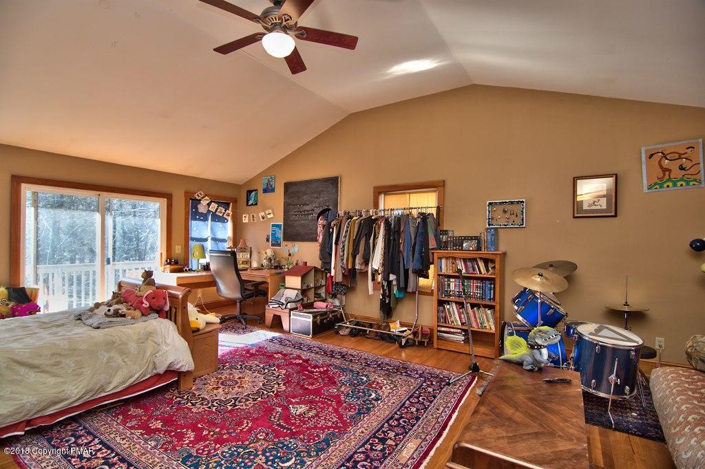 465 Pensyl Creek Road Stroudsburg, PA 18360 - Photo 31 of 80 a bed room with a bed a window and a chandelier