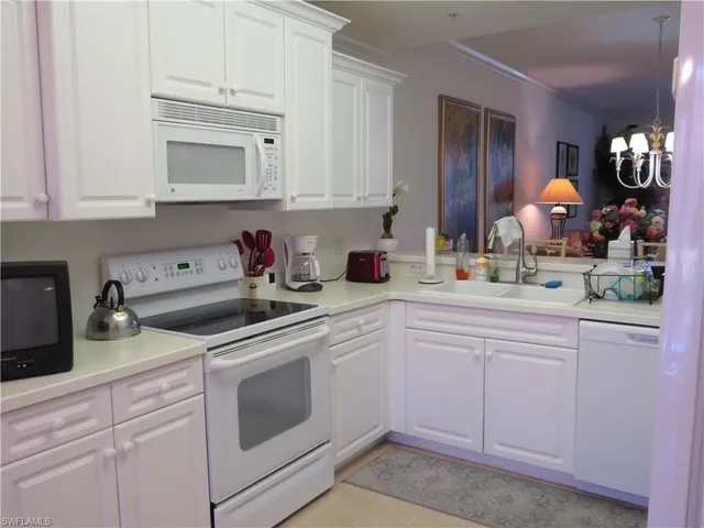 a kitchen with white cabinets and white appliances
