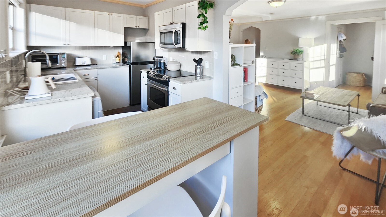 124 Warren Avenue North, Unit 310 Seattle, WA 98109 - Photo 2 of 12 a kitchen with granite countertop a sink cabinets stainless steel appliances and a counter top space