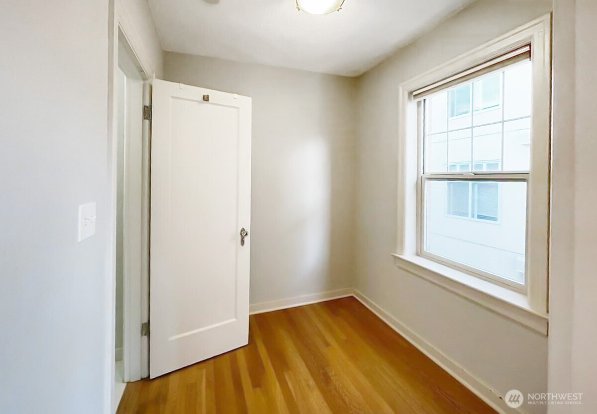 124 Warren Avenue North, Unit 310 Seattle, WA 98109 - Photo 5 of 12 a view of an empty room with a window and wooden floor