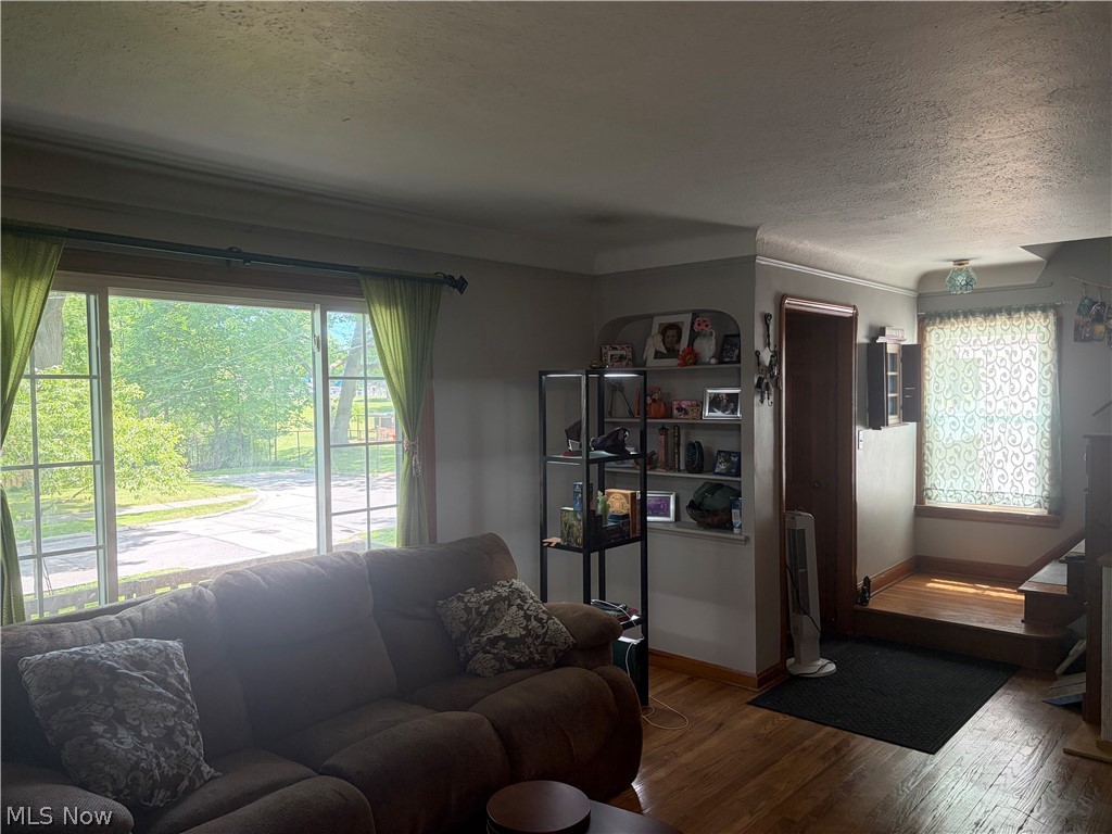 1604 Maplegrove Road South Euclid, OH 44121 - Photo 10 of 25 Living area with wood-finish flooring, a large multi-pane window, and a built-in wall niche with shelving
