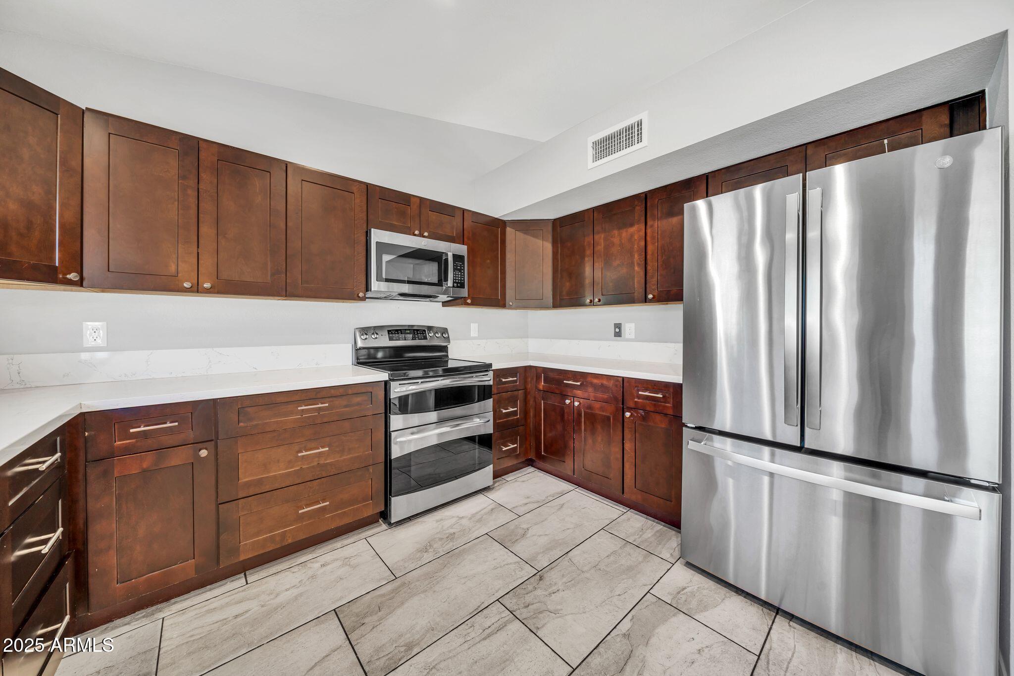 5044 East Paradise Lane Scottsdale, AZ 85254 - Photo 16 of 61 a kitchen with stainless steel appliances granite countertop a refrigerator stove top oven and sink