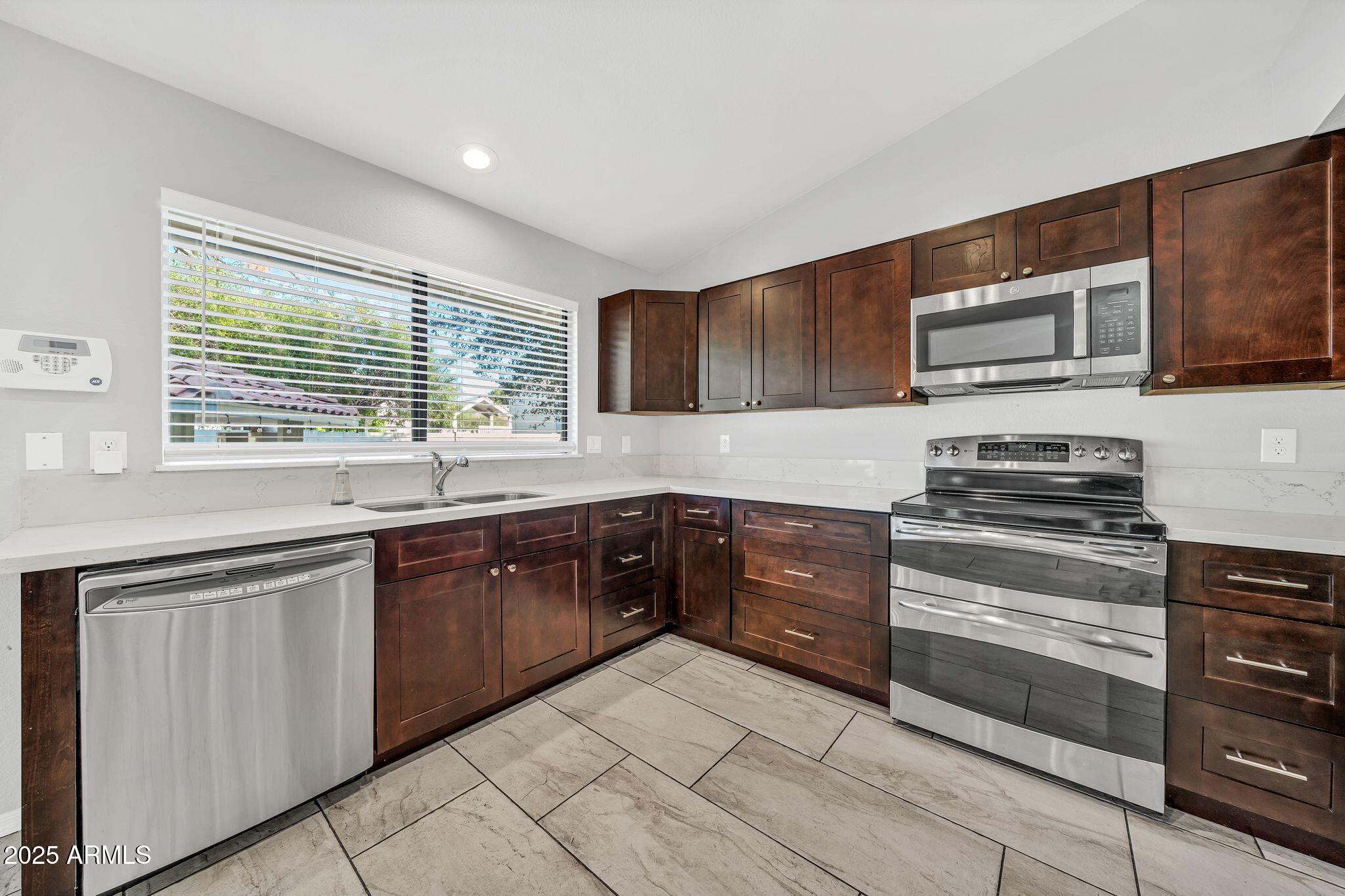 5044 East Paradise Lane Scottsdale, AZ 85254 - Photo 17 of 61 a kitchen with stainless steel appliances kitchen island granite countertop a stove sink and microwave