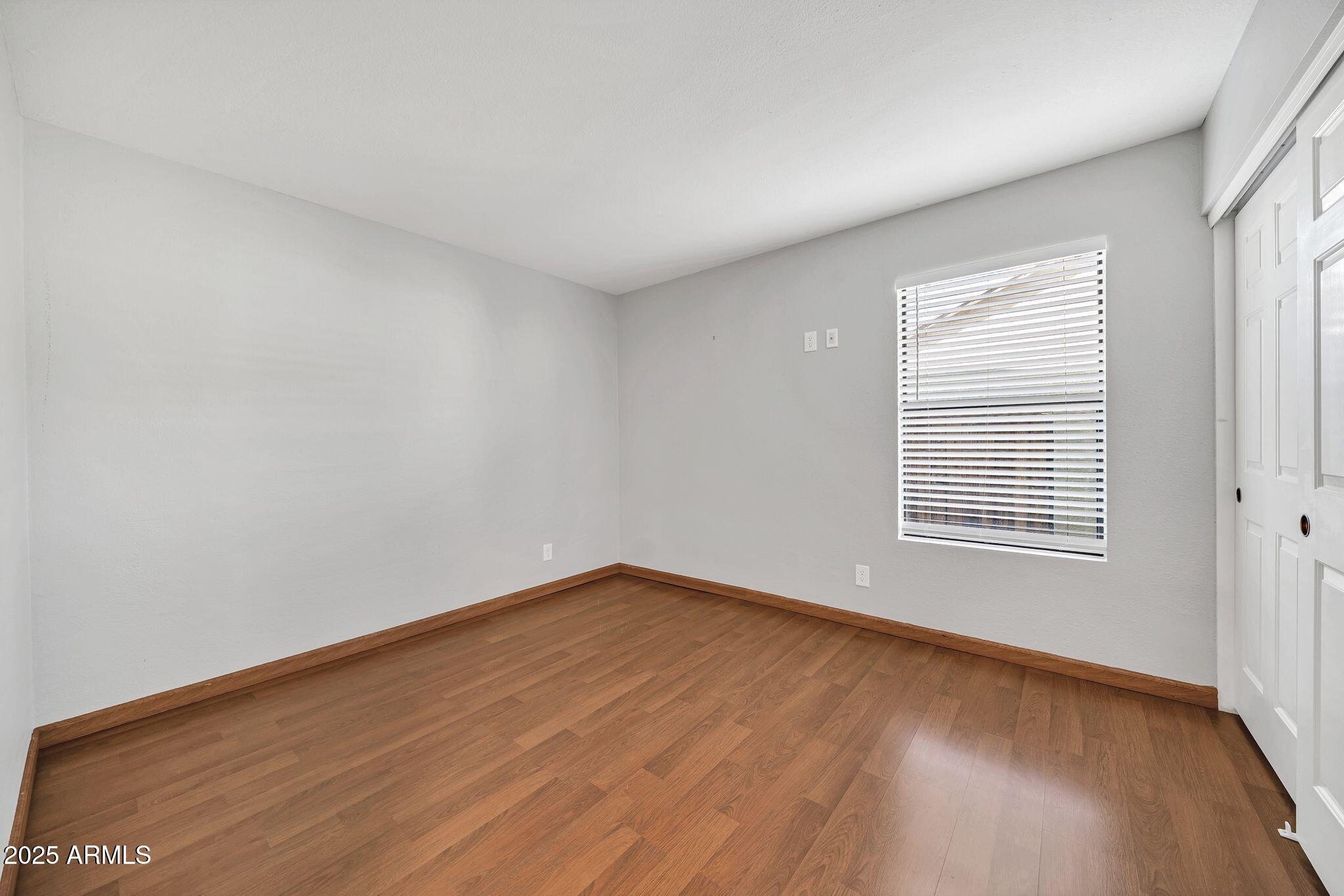 5044 East Paradise Lane Scottsdale, AZ 85254 - Photo 24 of 61 a view of an empty room with wooden floor and a window
