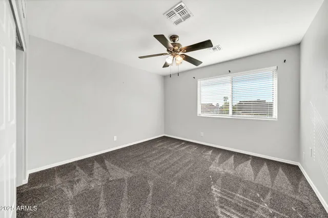 a view of empty room with ceiling fan
