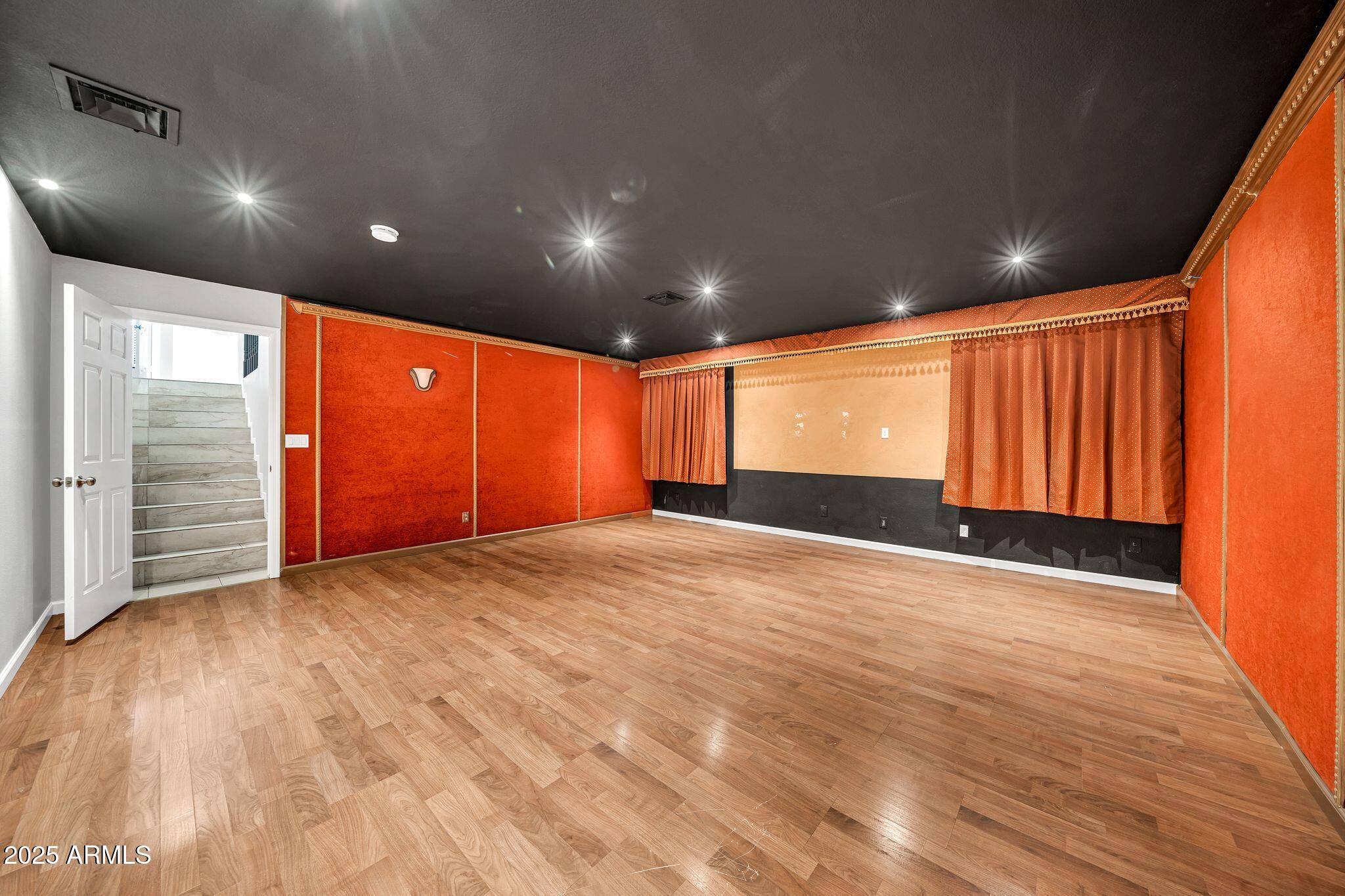 5044 East Paradise Lane Scottsdale, AZ 85254 - Photo 30 of 61 an empty room with wooden floor and windows with curtains