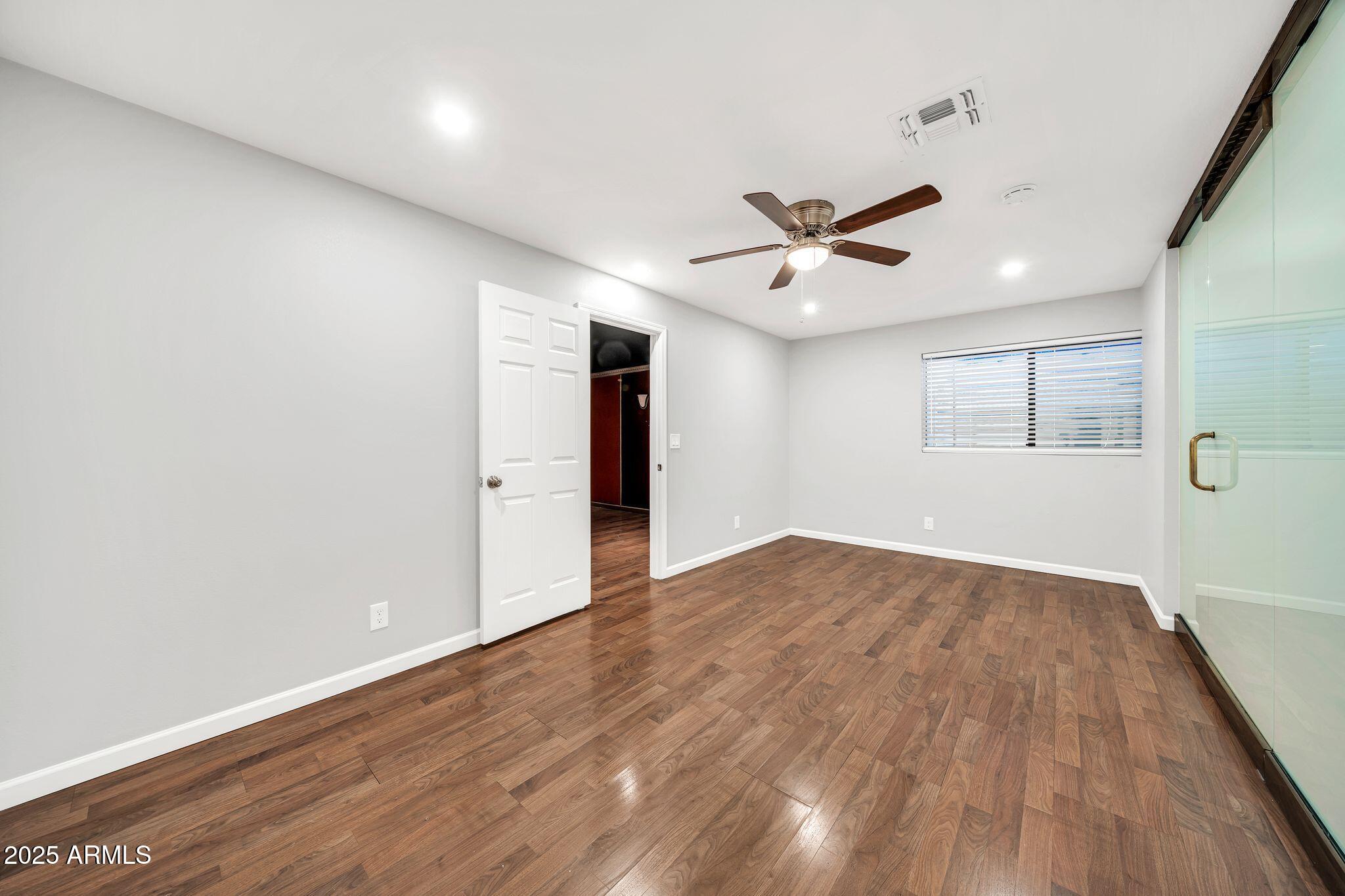 5044 East Paradise Lane Scottsdale, AZ 85254 - Photo 35 of 61 an empty room with wooden floor and windows