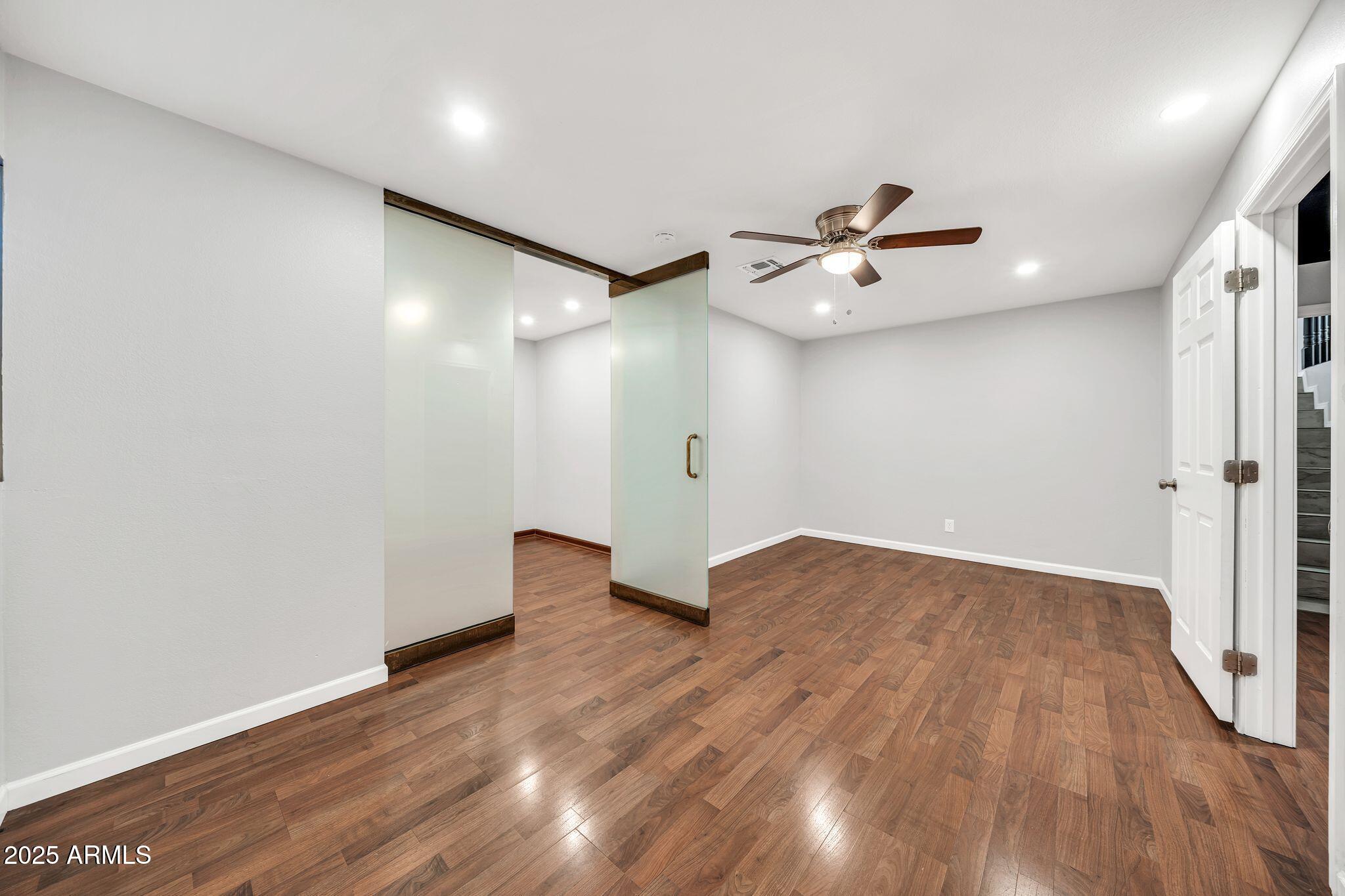 5044 East Paradise Lane Scottsdale, AZ 85254 - Photo 39 of 61 an empty room with wooden floor and a ceiling fan